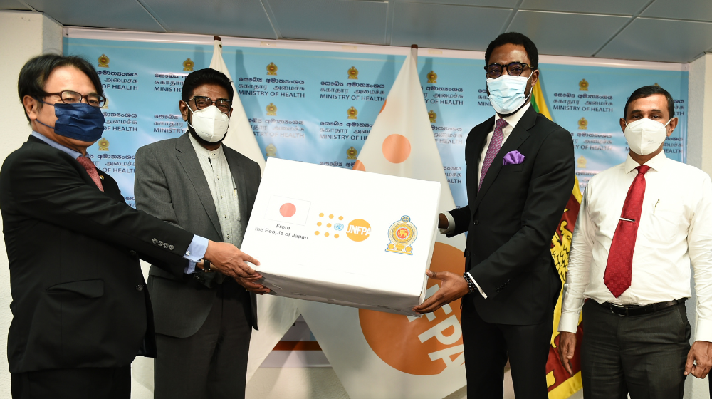 The UNFPA Representative and Japanese Ambassador hand over a box of essential medication & commodities to the Minister of Health